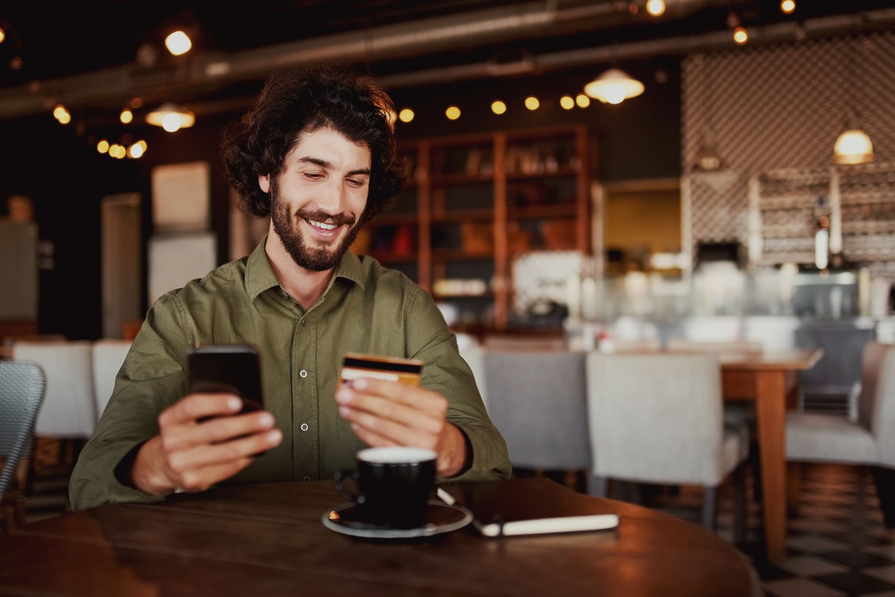 Man using phone in coffee shop
